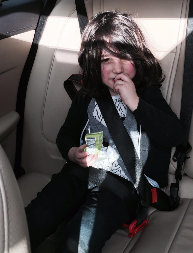 kid sitting in a car with mom sharing TRAVELING WITH A TODDLER