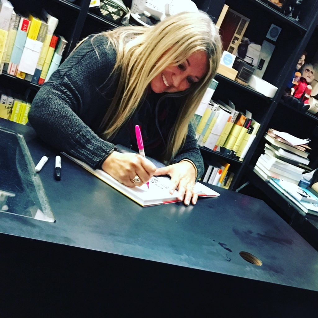CINDY WHITEHEAD  signing a book 