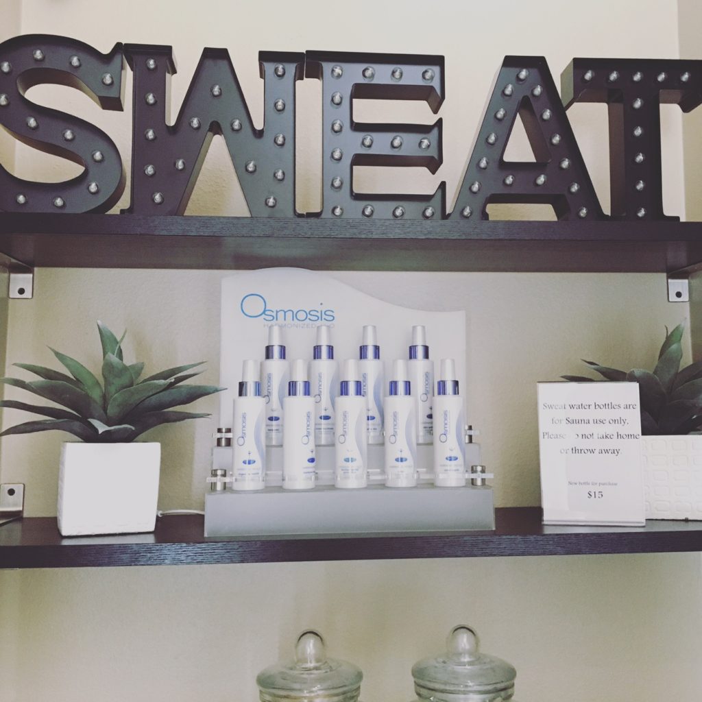 SWEAT metal signage and plants on a display rack