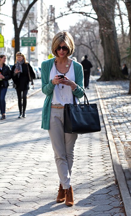 DEBRA BEDNAR CLARK in the street wearing jeans, white top, and cardigan and texting