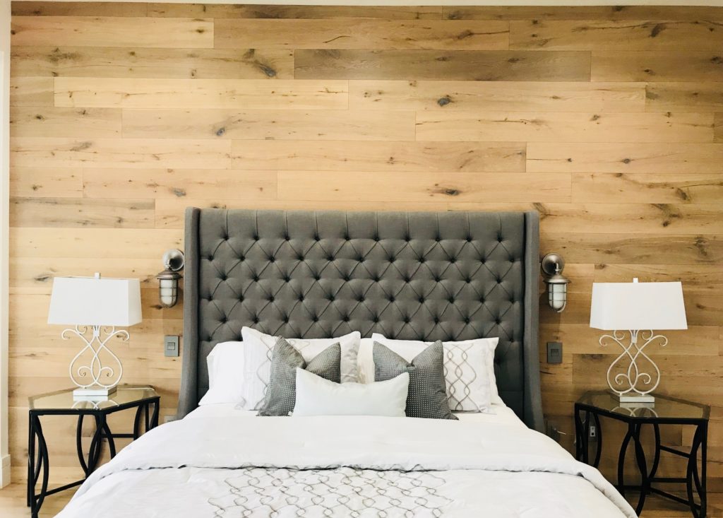 bed with headboard, two side tables with two white lamps 